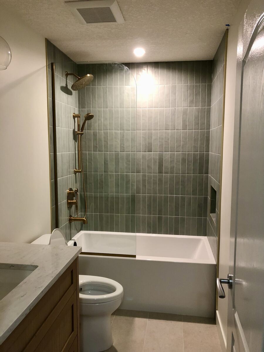 Brass vanity sconce lighting installation in a Calgary bathroom