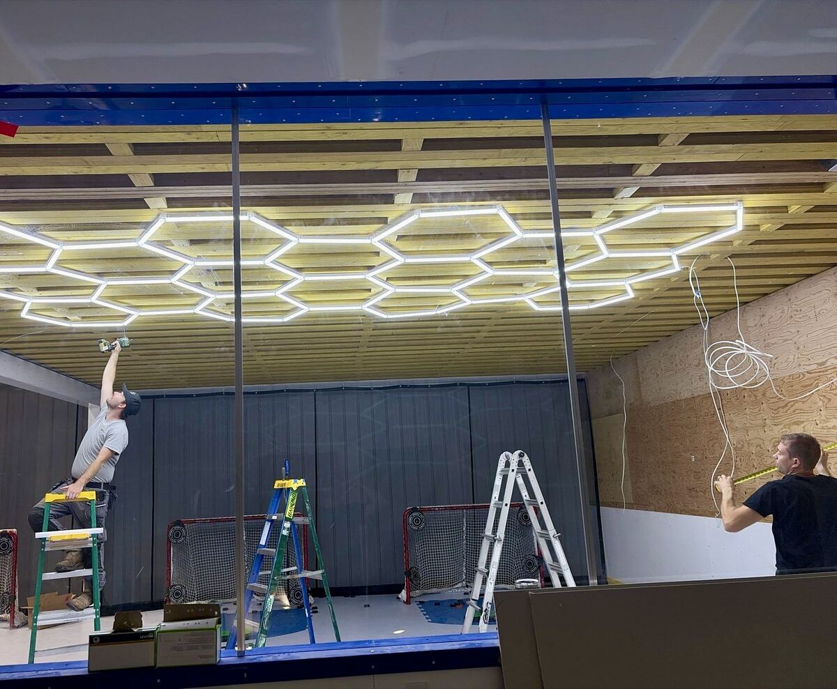 Custom hexagon LED lighting installation on a home ice rink ceiling