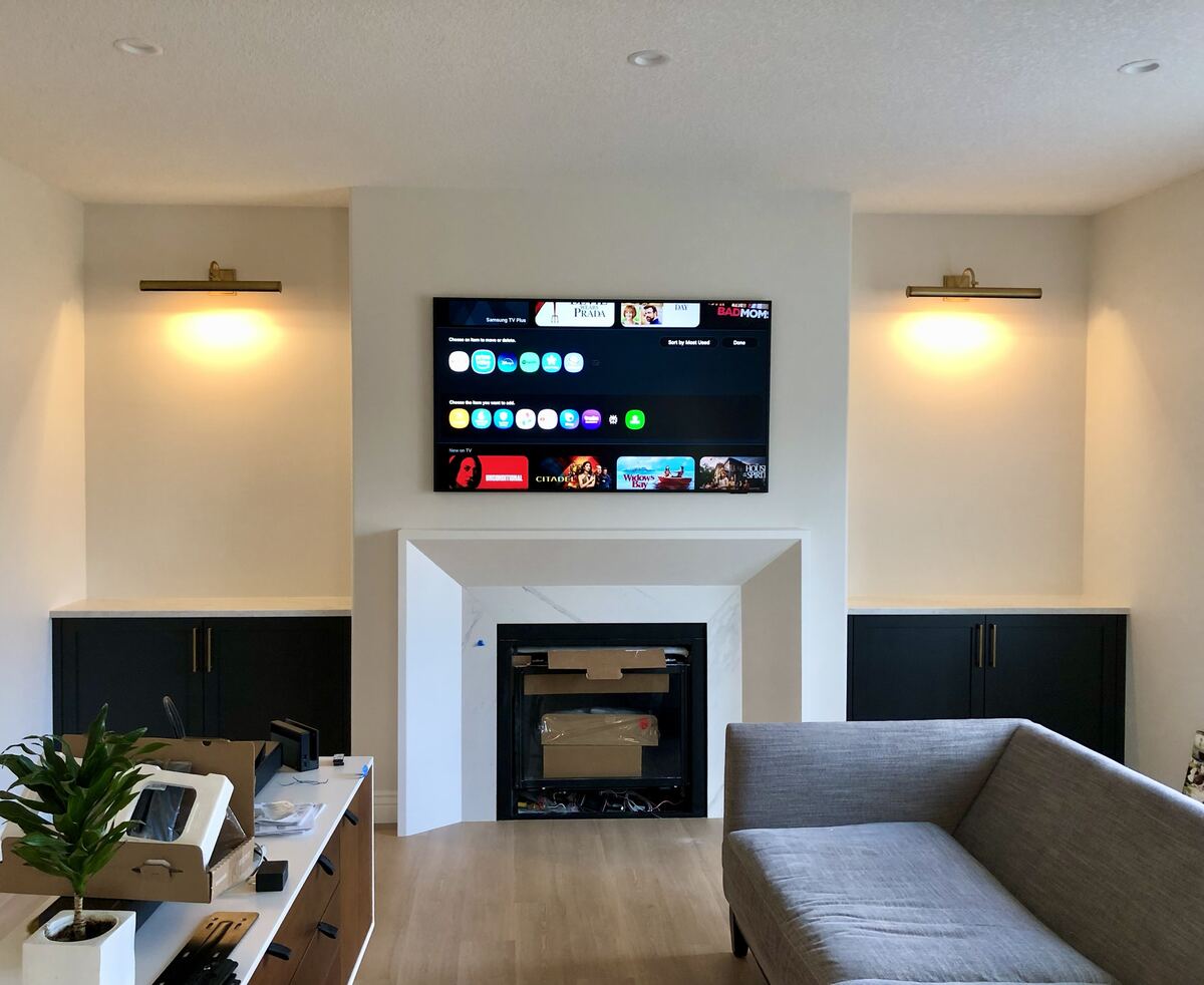 Wall-mounted TV wiring above a fireplace in a Calgary living room