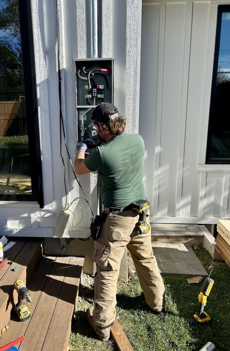 Electrician installing an exterior meter base connection